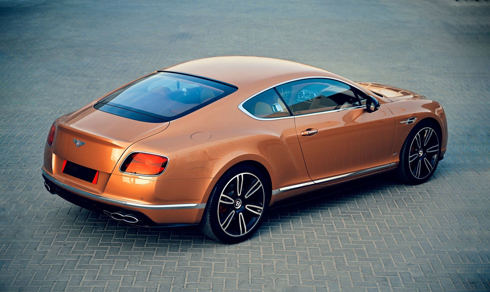 Bentley Continental GT cabriolet 2026 rouge garee devant Burj Al Arab a Dubai