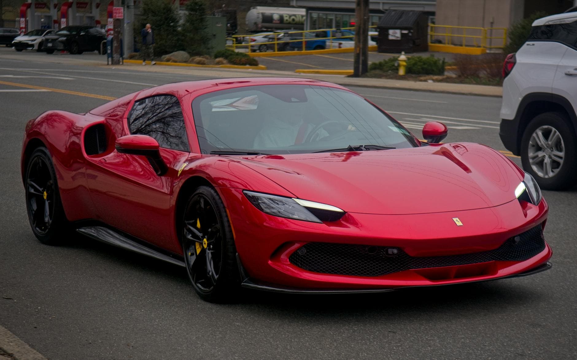 Red Ferrari 296 GTB parked in front of Burj Khalifa Dubai hybrid supercar rental 2026